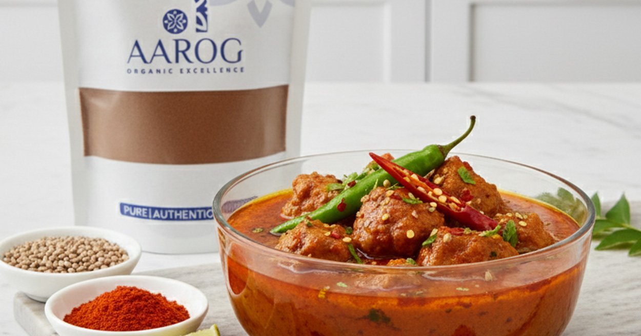 Aarog's Achar Gosht curry feature A bowl of rich, zesty Authentic Achar Gosht garnished with slit green chilies and fresh coriander.
